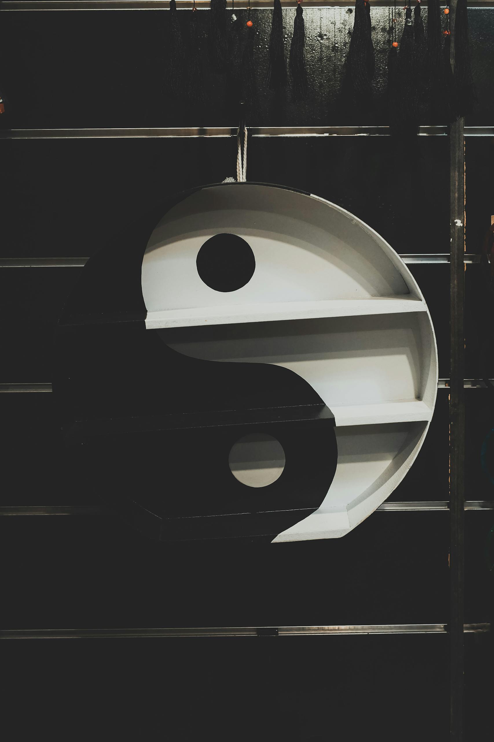 Striking yin yang wall art with shelves in black and white, perfect for modern decor.
